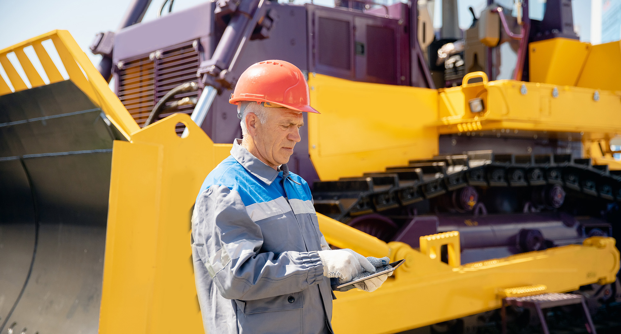 heavy equipment maintenance man tracking service plans on tablet