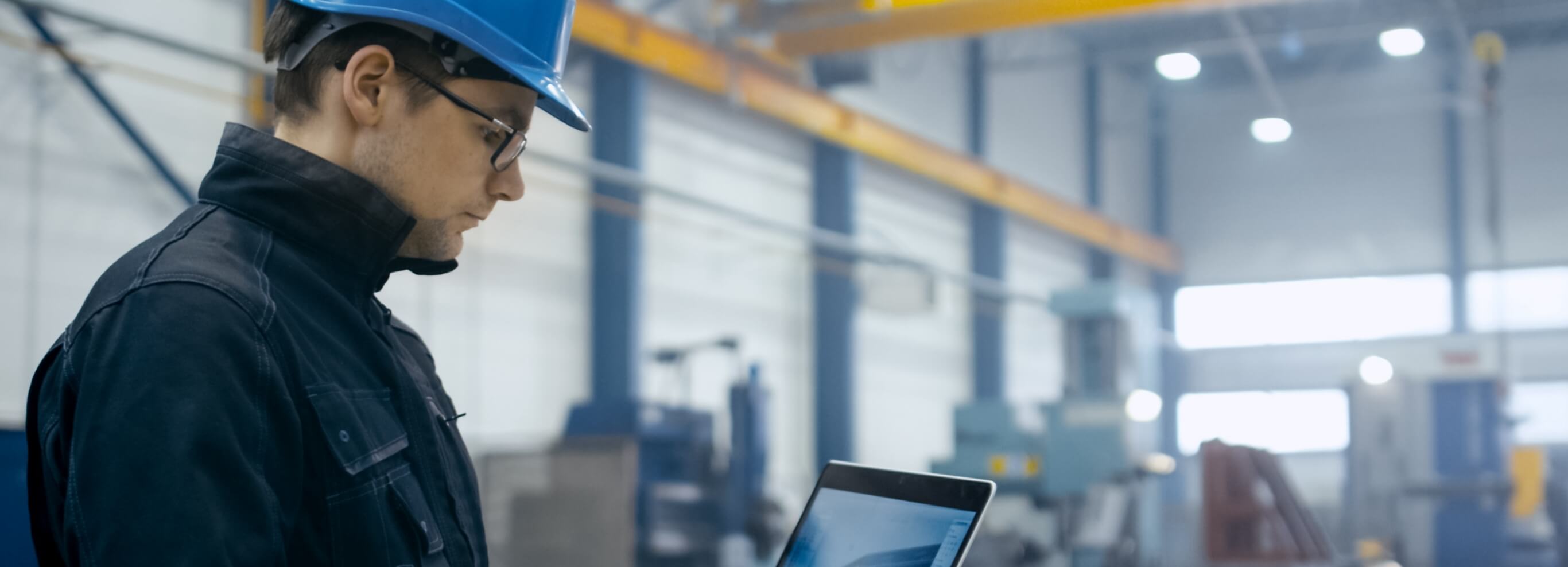 construction worker looking at a laptop in a warehouse